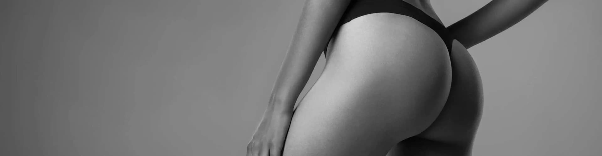 A black and white photo of a woman in a bikini, showcasing an Ultrasound Assisted BBL.