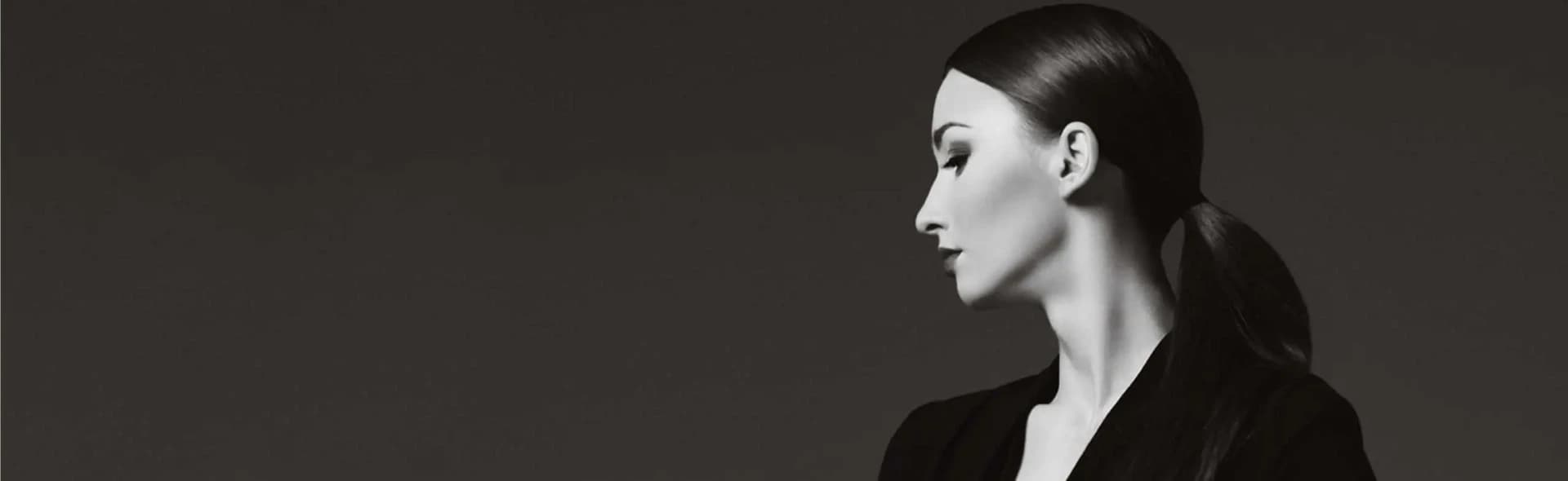 A black and white photo of a woman with a ponytail showcasing stunning facelift results.