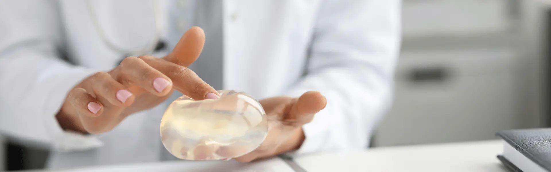 A woman in a white coat is holding a piece of plastic.