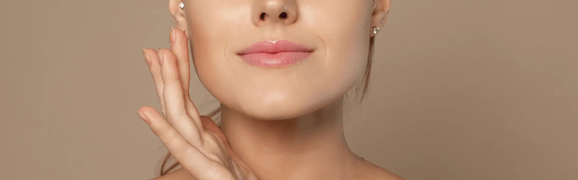 A woman's face with her hands on her face.