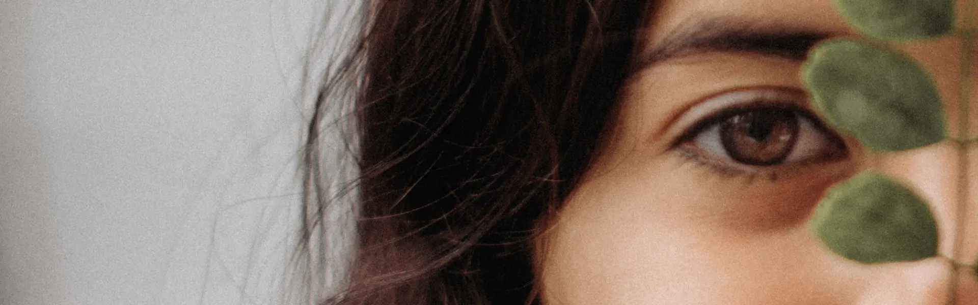 A woman's face with a plant in her eye.