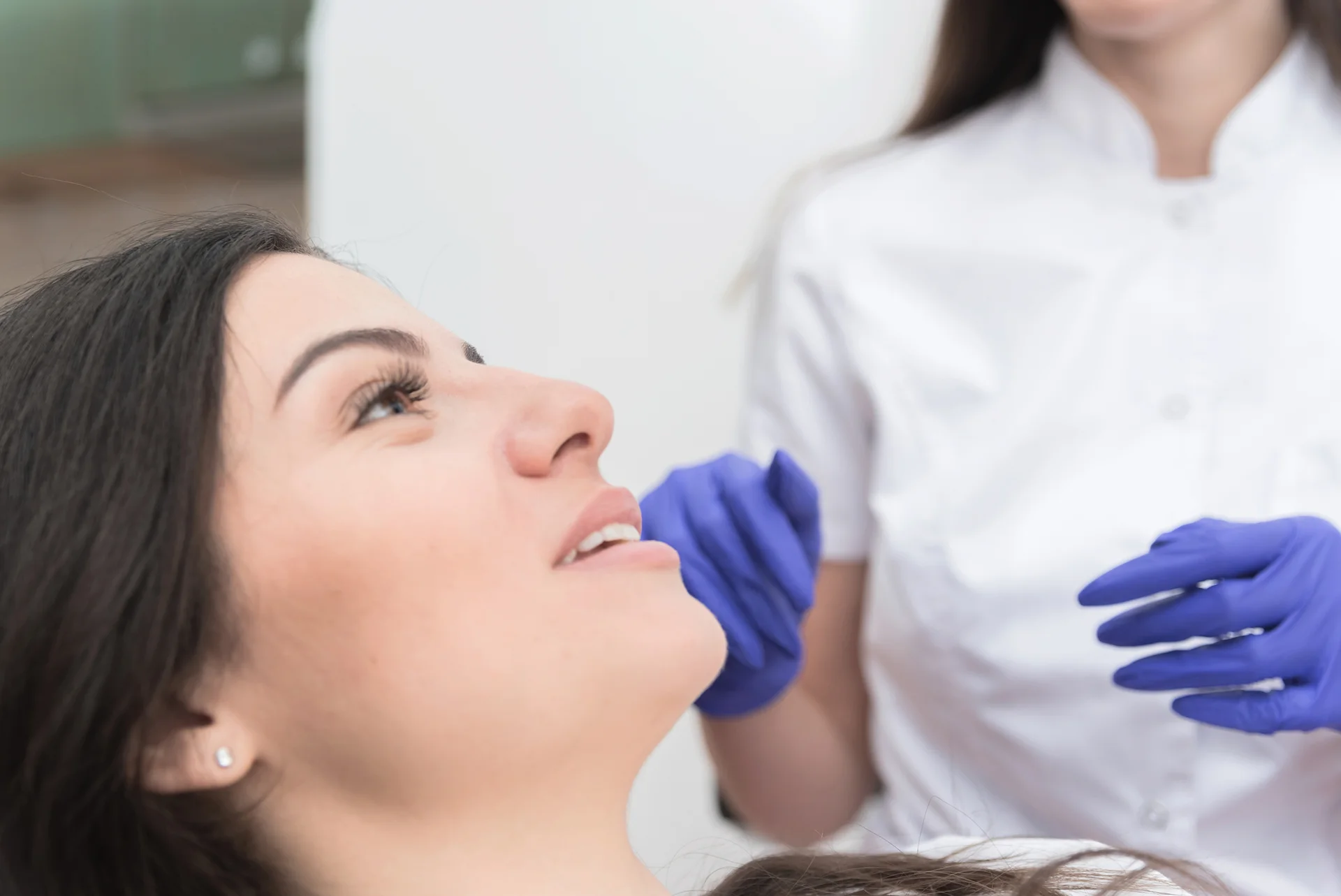 A woman is undergoing consultation to minimize swelling after chin liposuction.