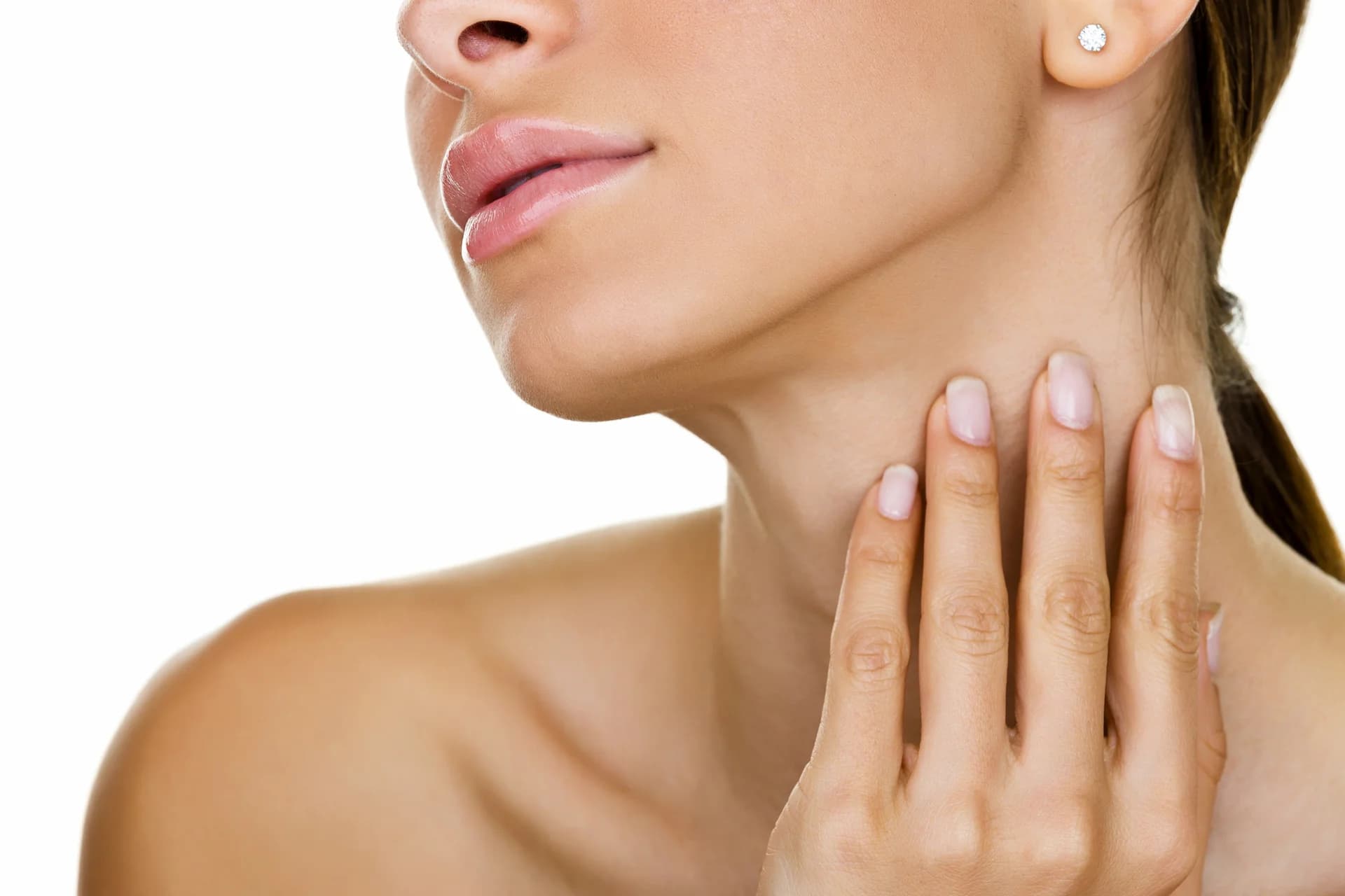 A woman is touching her neck with her hands, showcasing her defined jawline.