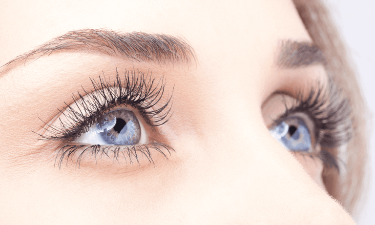 A close up of a woman's eyes with long eyelashes, showcasing their captivating beauty and allure.
