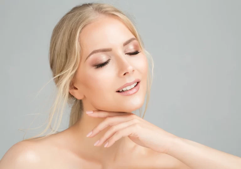 A beautiful young woman posing with her hands on her face showcasing the benefits of chin and neck lipo for facial contouring.