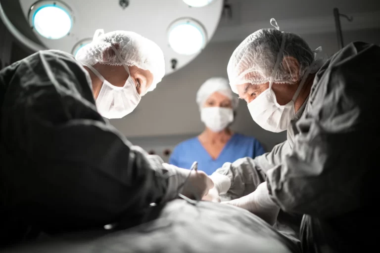 Two surgeons performing Kybella injections on a patient in an operating room.