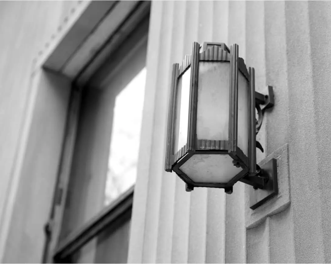 Our Practice - A black and white photo of a street light on the side of a building.