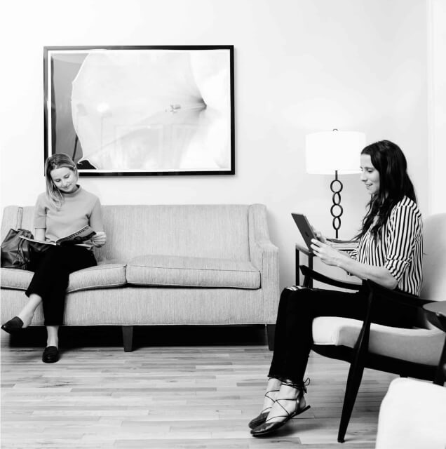 Black and white photo of two women sitting in a living room.