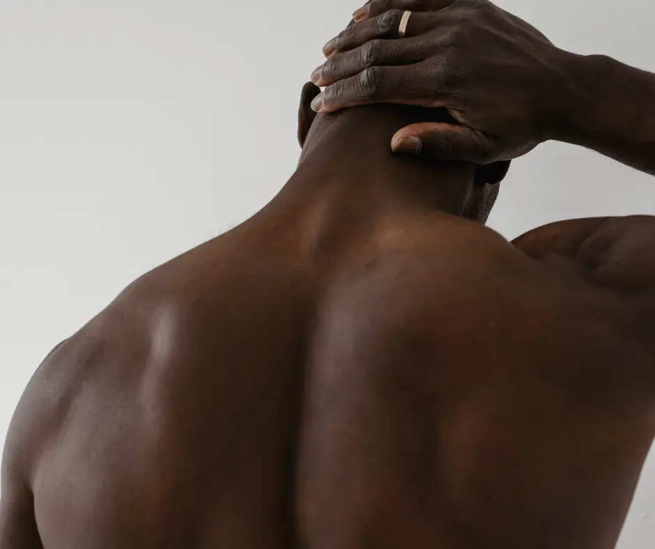 A black man with a buffalo hump putting his hand on his back.