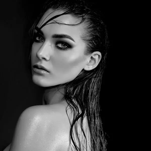 A black and white photo of a woman with wet hair, highlighting her chin.
