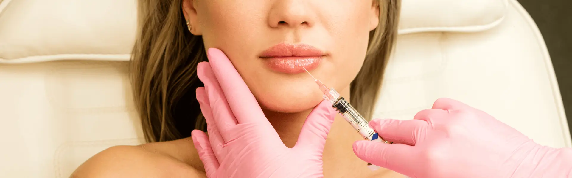 A woman getting a lip injection in a clinic.