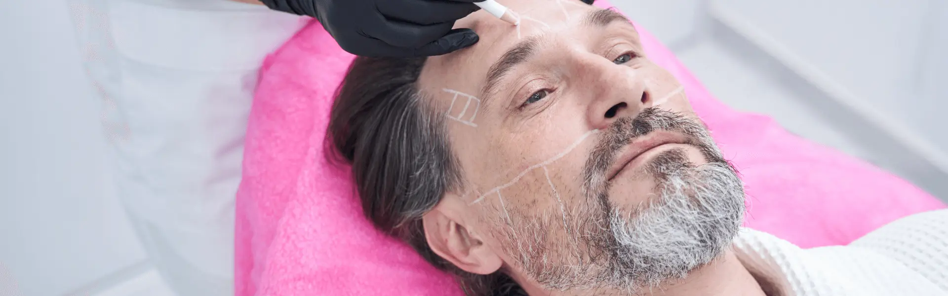 A man with a beard getting a facial treatment.