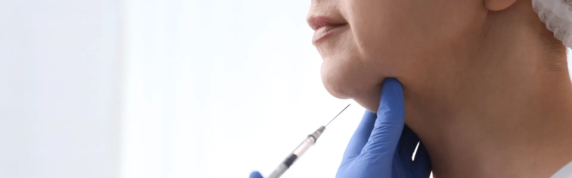 A woman's neck is being injected with a syringe.