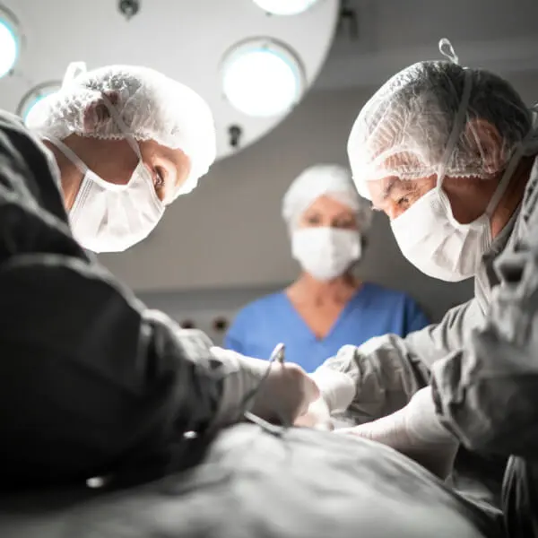 Surgeons performing stomach surgery on a patient in an operating room.