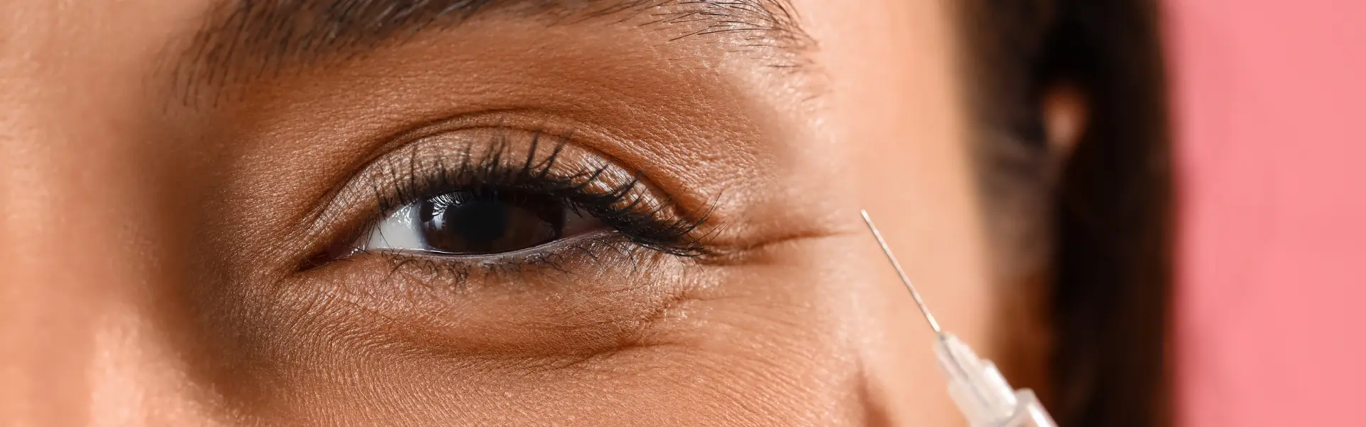 A woman's eye is being injected with a needle.