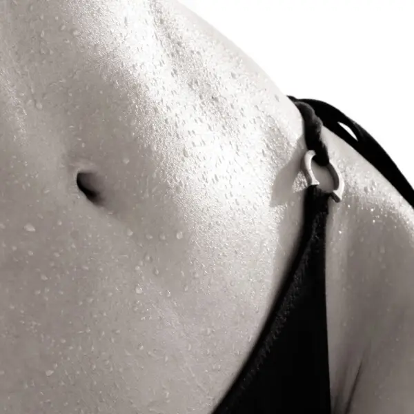 A close up of a woman's belly undergoing VASER liposuction.