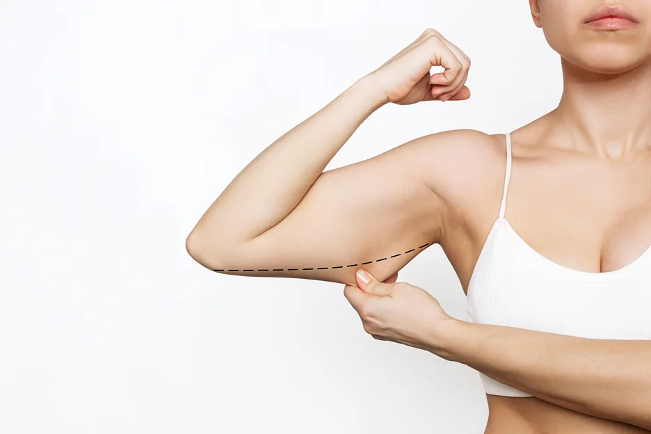 A woman displaying her toned arm muscles after a workout.
