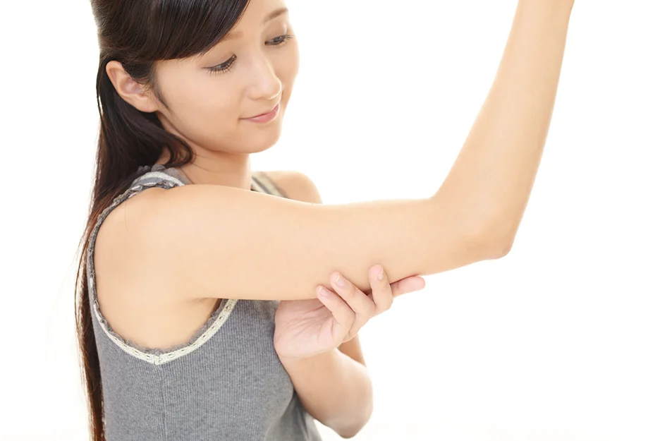 A woman is pointing at her slim arm