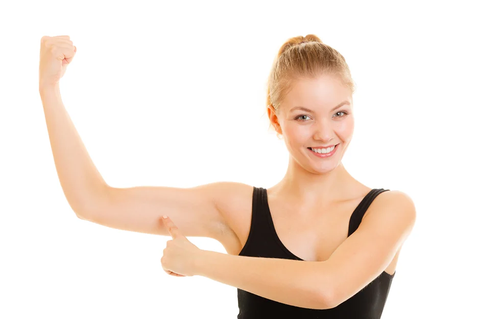 A young woman flexing her toned arms 