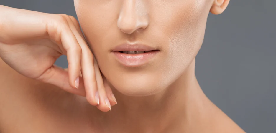 Close up of a woman's face undergoing non-invasive chin fat reduction treatment.