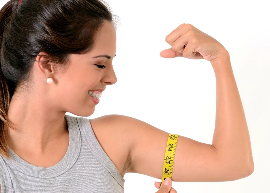 A woman measuring her arm after Arm Liposuction