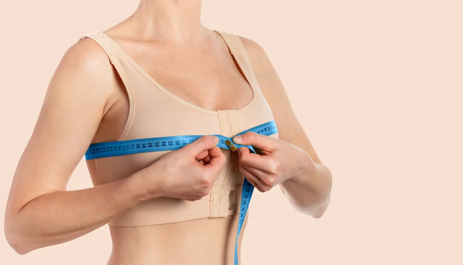 A Woman Measuring Her Breast After Breast Augmentation